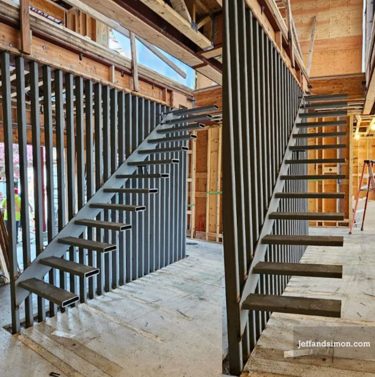 Custom steel staircase under construction, double stringer frame with iron picket guard by Vancouver Stairs